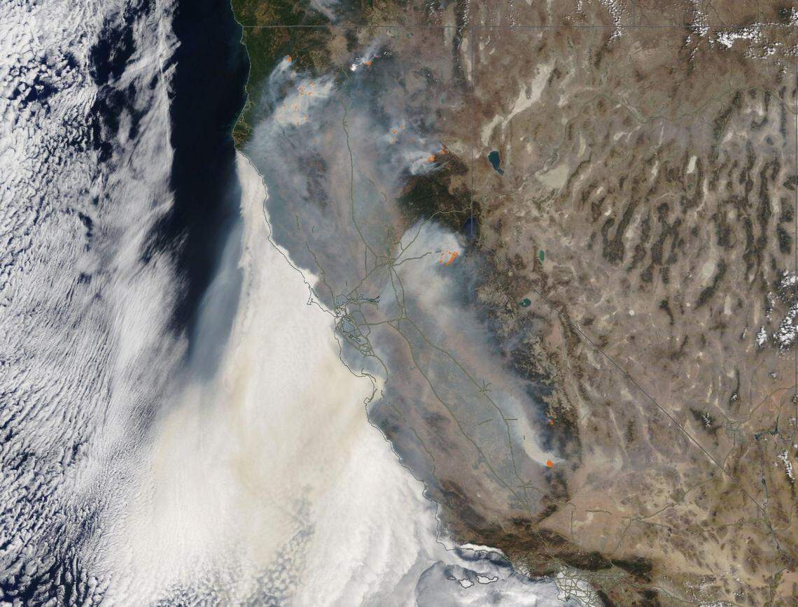 A satellite image from Saturday, Aug. 20, 2021, shows how wildfires are pumping smoke into California’s Central Valley, where it is being trapped by mountain ranges surrounding the valley. The smoke is creating unhealthy air quality for the region’s residents.
