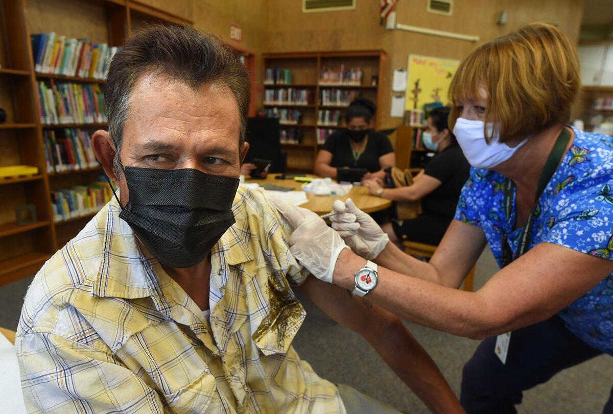 Dairy worker Jose Mariscal gets his COVID-19 vaccination from Tulare County registered nurse Cynthia Norvill during a clinic at the Tipton Library on July 29, 2021. He said has become worried about the spread of the disease and was doing it to protect his family.