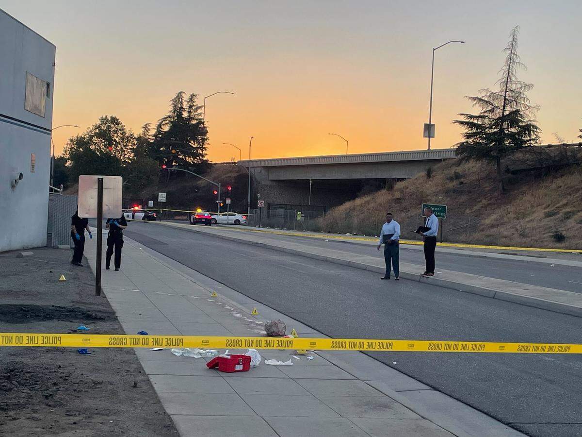 Investigators at the scene of a homicide in the area of Fulton Street and Belmont Avenue, just north of Highway 180 in Fresno, early Saturday morning, Sept. 24, 2022.