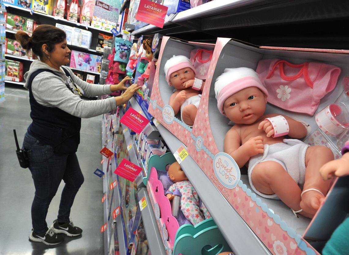 Next to a shelf of realistic dolls, Christian Rivera works in the toy section of the new Walmart Supercenter at Shaw and Brawley, Tuesday morning, Oct. 23, 2018.