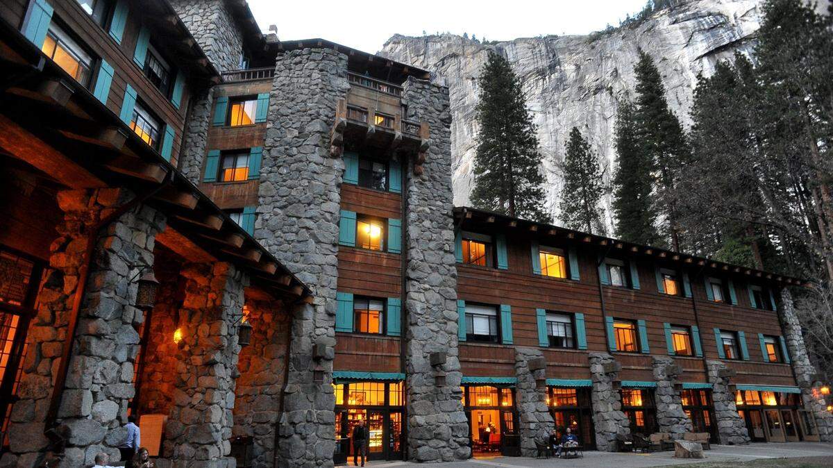 The historic Ahwahnee Hotel lit up as dusk falls over Yosemite Valley.