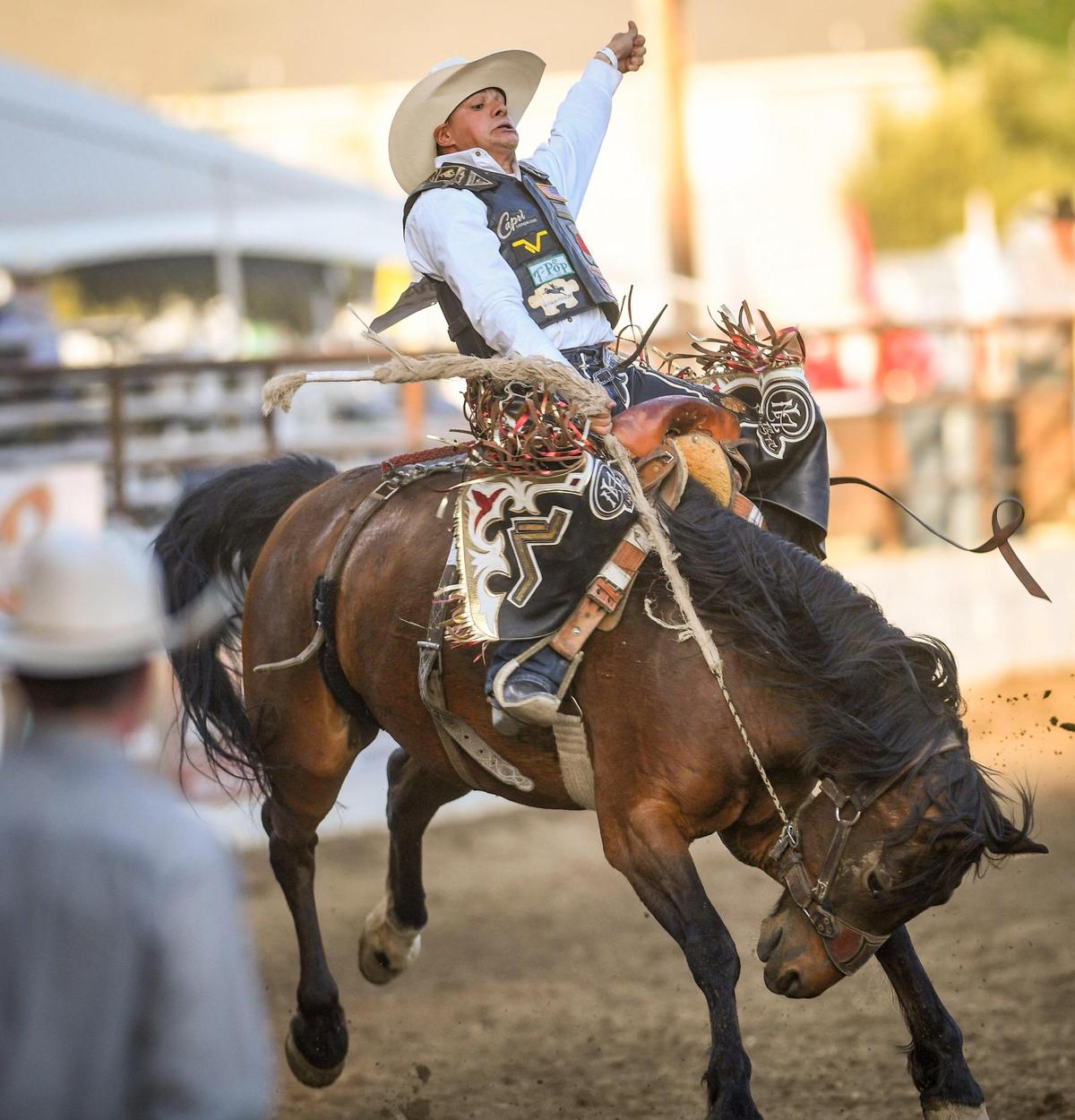 Lefty Holman of Visalia hangs on while riding Scarlet Lady in the saddle bronc riding section of the PRCA event at the Clovis Rodeo on Thursday, April 23, 2021.