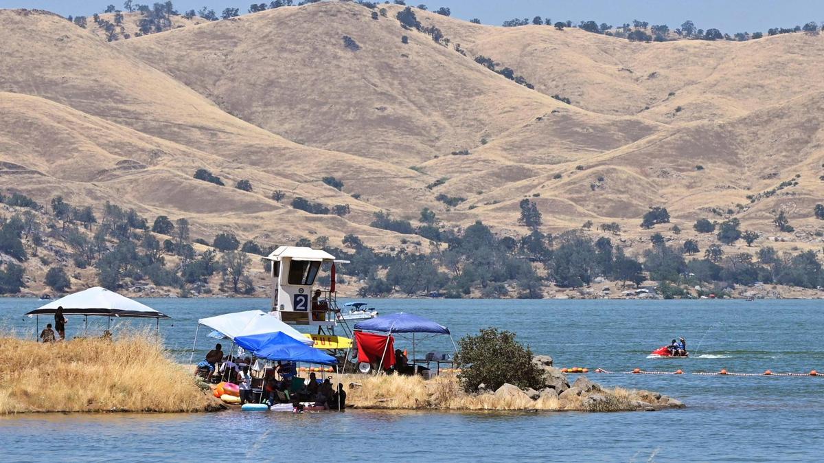 A lifeguard keeps watch as families seek relief from triple digit temperatures in Millerton Lake Saturday, July 15, 2023 near Friant.