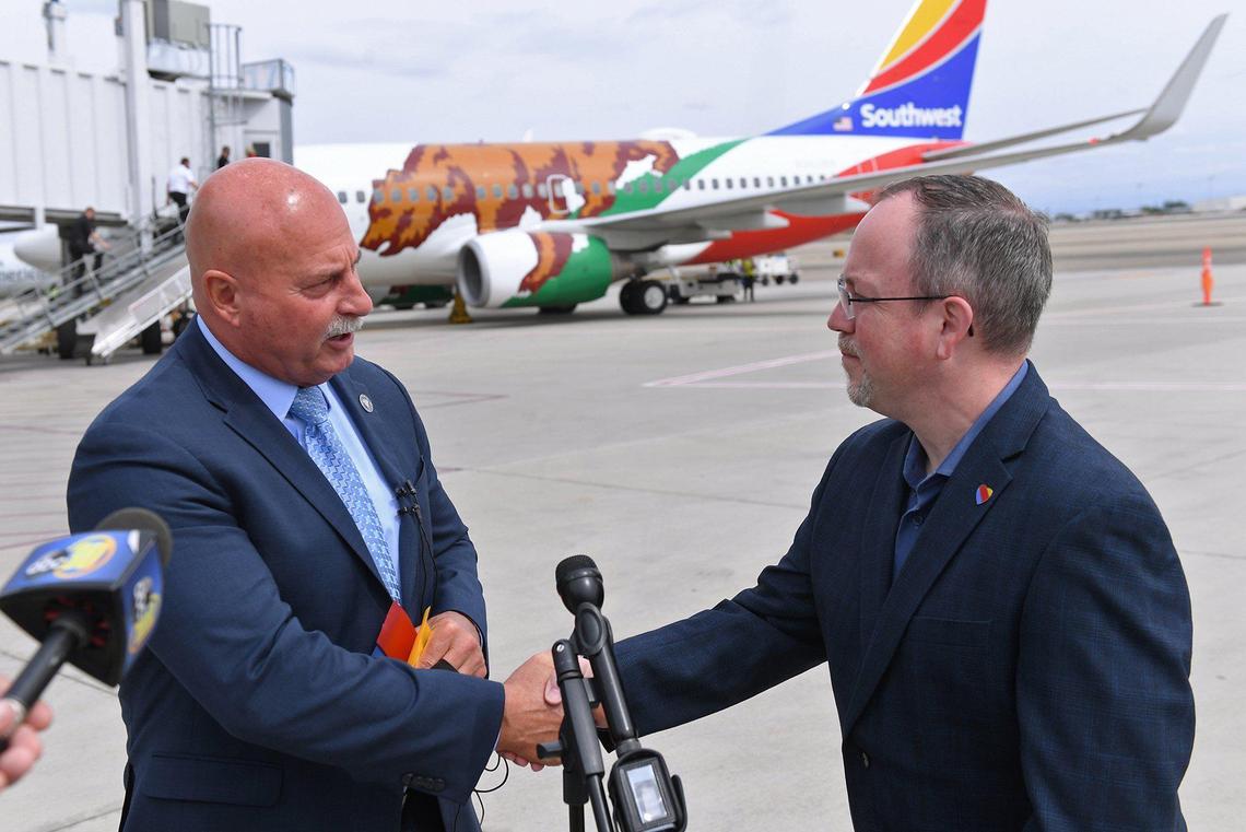 Fresno Mayor Jerry Dyer, let, shakes Southwest Airlines vice-president of Network Planning Adam Decaire, right, with ‘California One’ in the background preparing for its inaugural flight leaving Fresno Yosemite International Airport for Las Vegas Sunday morning, April 25, 2021 in Fresno.