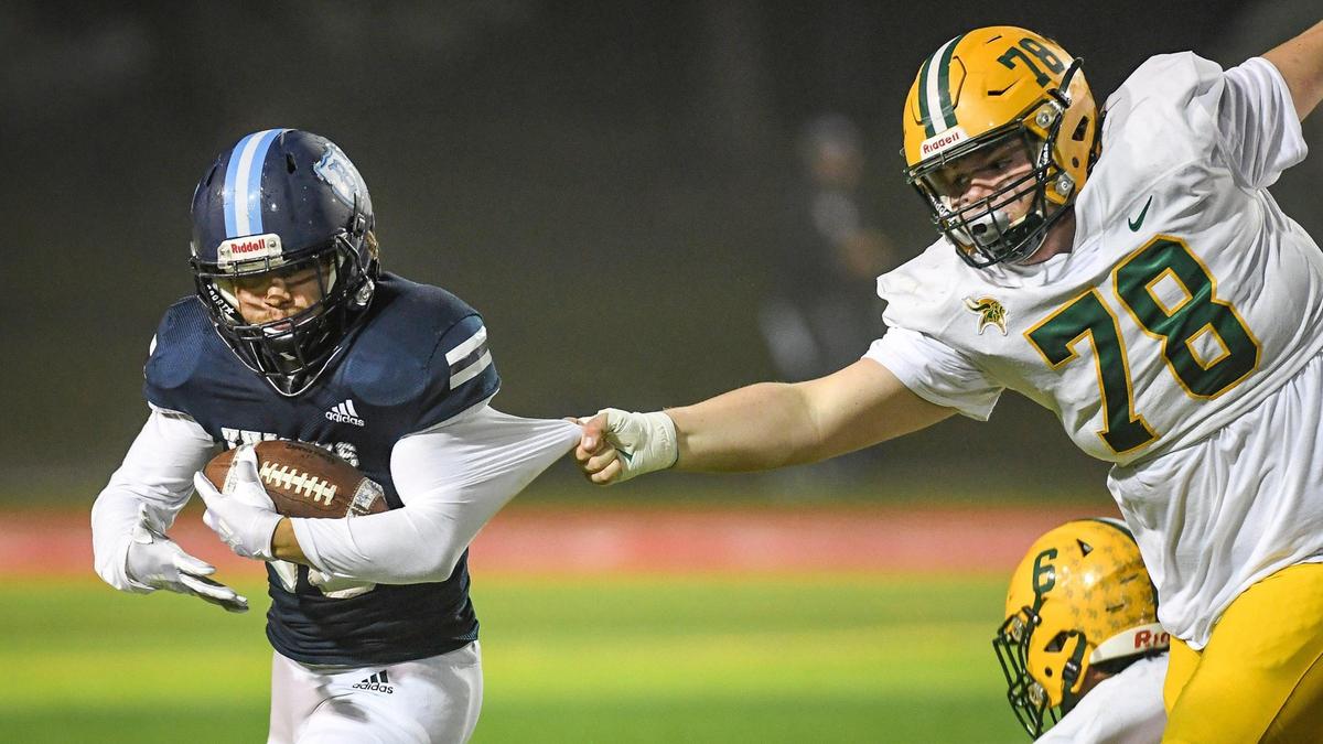 Bullard running back Herman Zamora tries to turn the corner on a run as Kingsburg’s Jake Bray grabs him by the shirt in their Central Section Division II semifinal Friday, Nov. 19, 2021, at McLane Stadium.