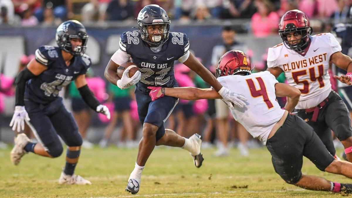 Clovis East running back Lamaj Travis slips by Clovis West’s Bryan Gutierrez for yards up the middle during the first half of their game at Lamonica Stadium on Friday, Oct. 7, 2022.
