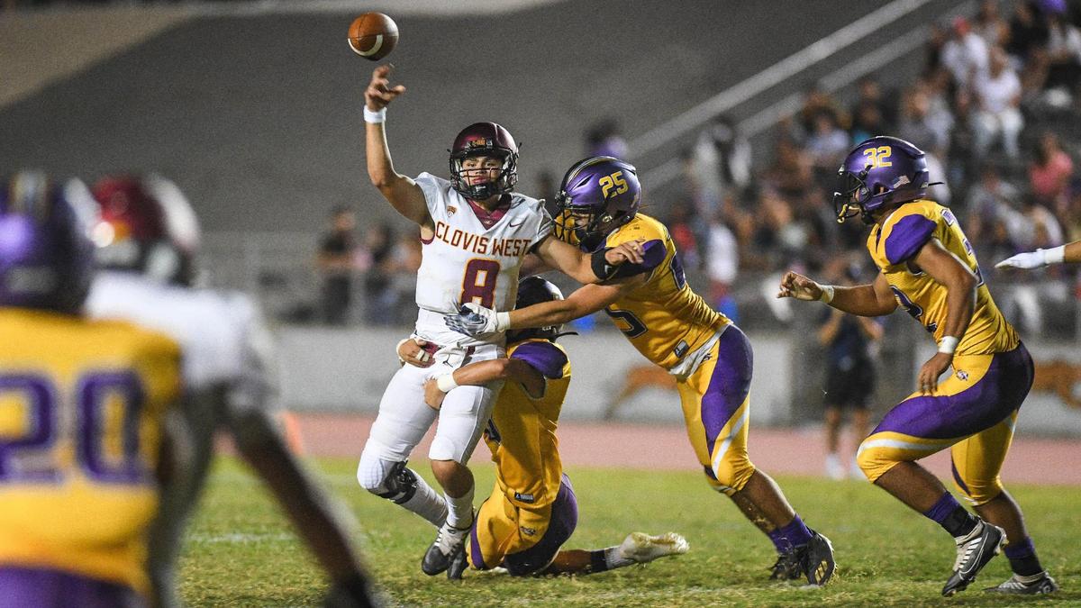 Clovis West quarterback Ryan Markarian gets a pass off just as the Lemoore defense wraps him up in the second half of their game at Lemoore High on Friday, Sept. 2, 2022.