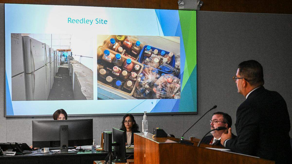 Fresno County Assistant Director of Public Health Joe Prado, right, projects images of refrigerators, freezers and various liquids found in a Reedley warehouse run by a Chinese-owned company under investigation for operating illegally, during a timeline presentation at the Fresno County Board of Supervisor’s meeting on Tuesday, Aug. 8, 2023.