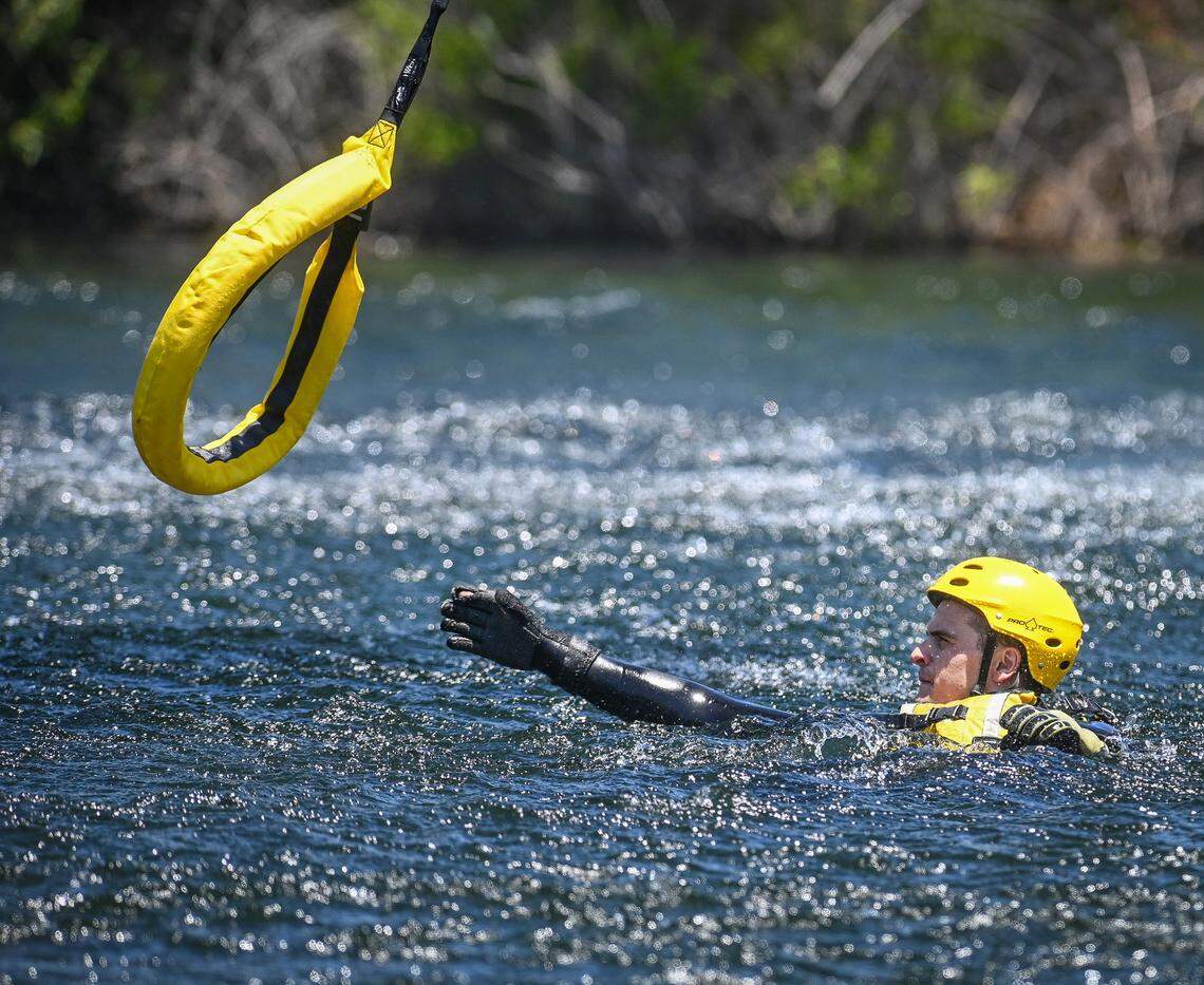 Trevor Marriott, a Fresno State criminology 108 reserve program participant with the Fresno County Sheriff’s Department reaches for a rescue sling dropped from the department’s Eagle One helicopter during swift water rescue training on the San Joaquin River at Lost Lake park on Monday, June 6, 2022.