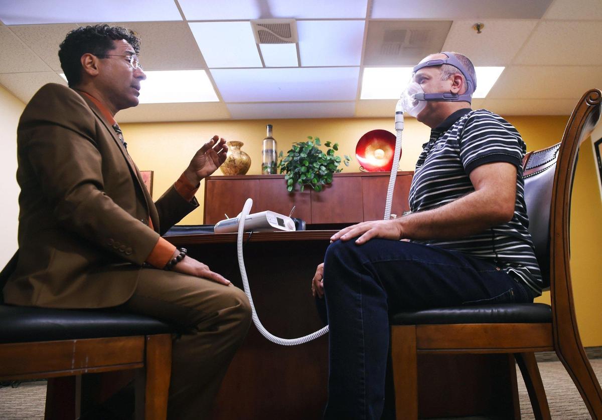 Dr. Arnold Rugama, M.D., left, helps Marek Warszawsk, right, use a CPAP full face mask at Fresno Sleep Specialists, Inc. Thursday, June 27, 2019 in Fresno.