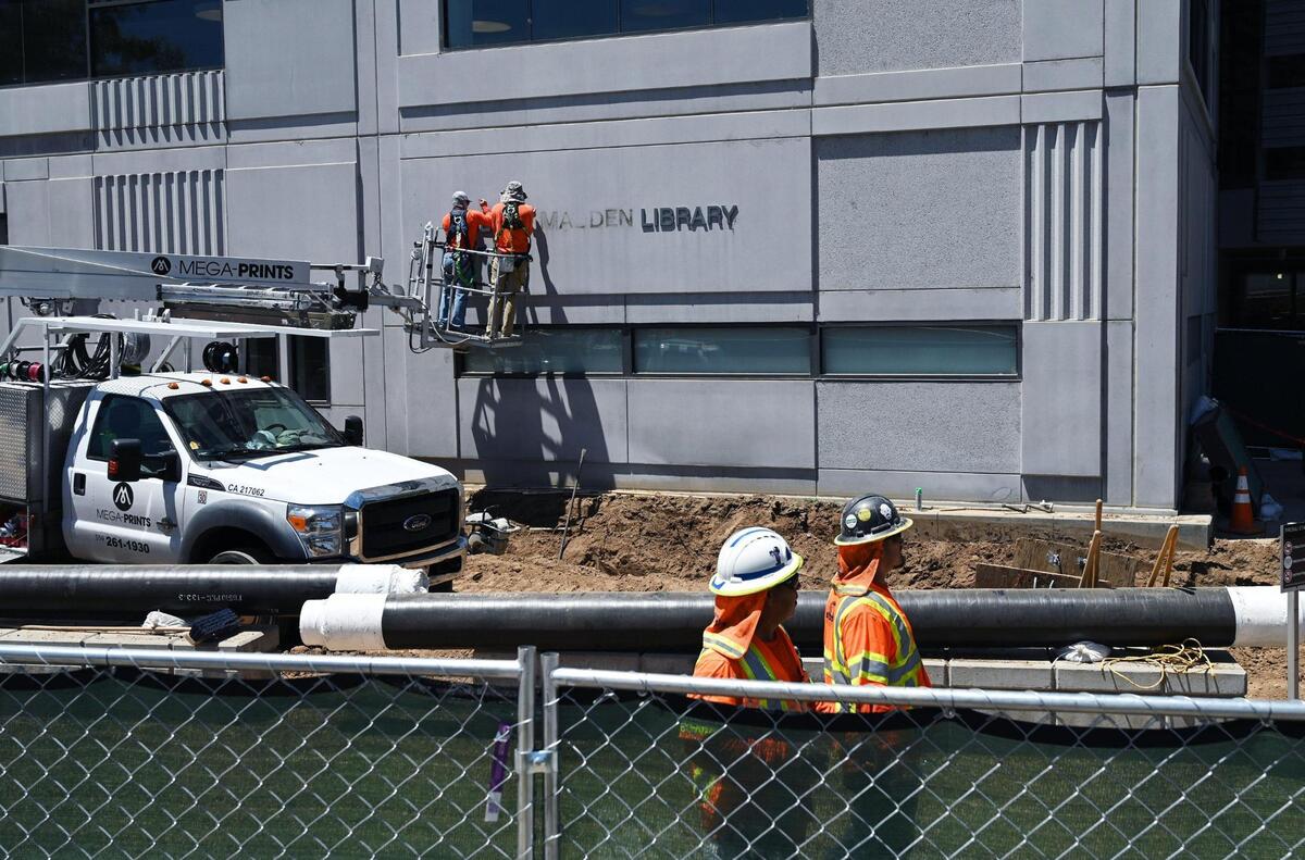 Workers remove Henry Madden’s name from the east side of Fresno State’s library Wednesday, July 20, 2022 in Fresno. The California State University system’s board of trustees approved the removal of Madden’s name from Fresno State’s University Library, following discovery of his deeply held anti-Semitic views and Nazi sympathies. Lisa Bell, with Fresno State Communications, said a naming task force will be created to determine a new name which may take a year to finalize.
