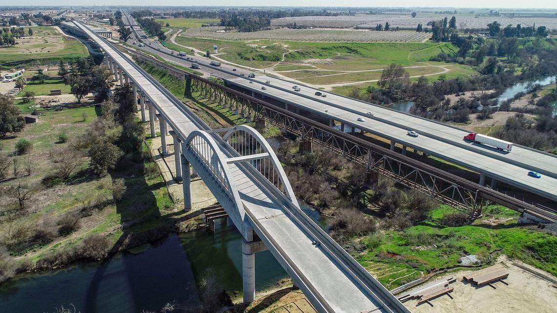 A bridge for the California High Speed Rail crosses the San Joaquin River, at left, with Highway 99 and the Union Pacific Railroad at right, during construction of the bullet train railway on Thursday, March 4, 2021.