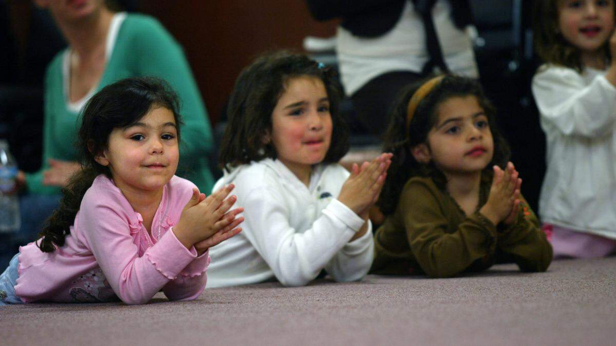 Grace Colarian, far left, Brianna Nishian and Alik Kutumian applaud after hearing a fellow student perform on the piano with nine other children from the Armenian Community School in this 2007 photo.