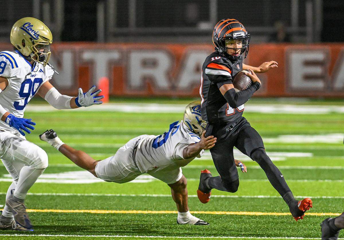 Central East quarterback tries to get past the Clovis defense on a keeper in their game at Koligian Stadium in Fresno on Friday, Oct. 24, 2025.