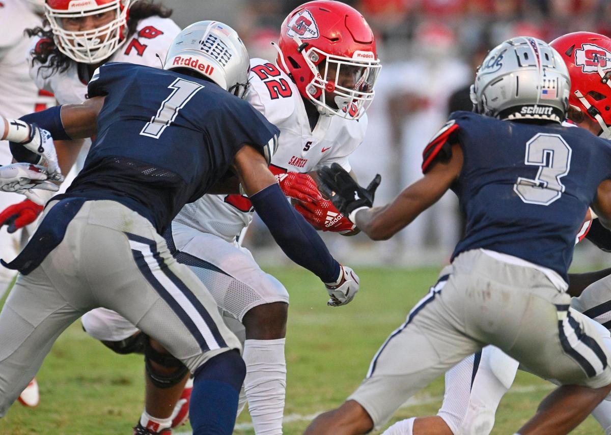 Sanger’s Israel Robles, center, runs against the Clovis East defense in the Silver Spear trophy game Thursday, Aug. 31, 2023 in Clovis. Clovis East won 42-21.
