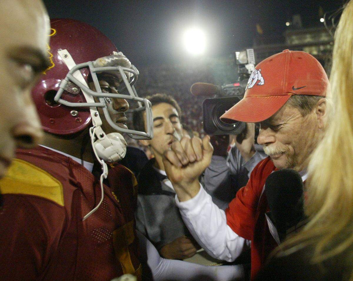 Fresno State coach Pat Hill congratulates USC's Reggie Bush after their game. 
