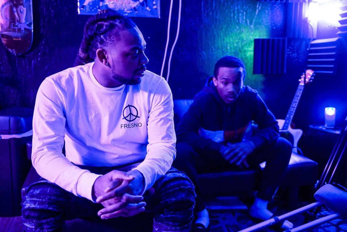 Local rapper Syrup, left, whose real name is Roger Brown, an Advance Peace “change agent,” talks with an Advance Peace fellow during a recording session in Fresno on Wednesday, March 17, 2021.