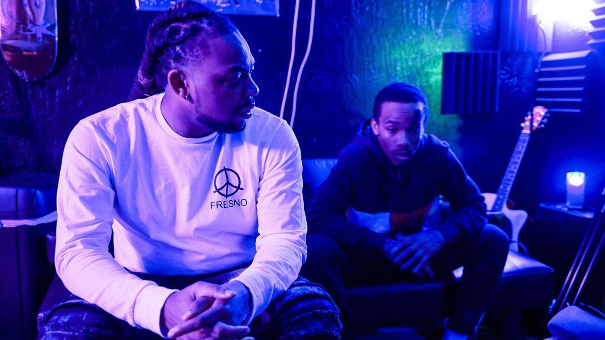 Local rapper Syrup, left, whose real name is Roger Brown, an Advance Peace “change agent,” talks with an Advance Peace fellow during a recording session in Fresno in 2021.