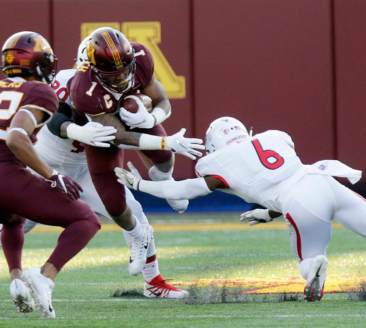Fresno State cornerback Tank Kelly (6) and defensive tackle Kevin Atkins (90) bring down Minnesota running back Rodney Smith (1) in the first quarter of the Bulldogs’ 21-14 loss to the Golden Gophers, Saturday, Sept. 8, 2018, in Minneapolis.
