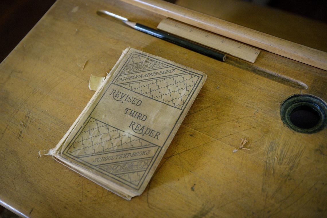 A book sits on one of the old desks in the classroom of the original Allensworth schoolhouse built in 1912 at Colonel Allensworth State Historic Park near Earlimart on Thursday, Feb. 7, 2019.