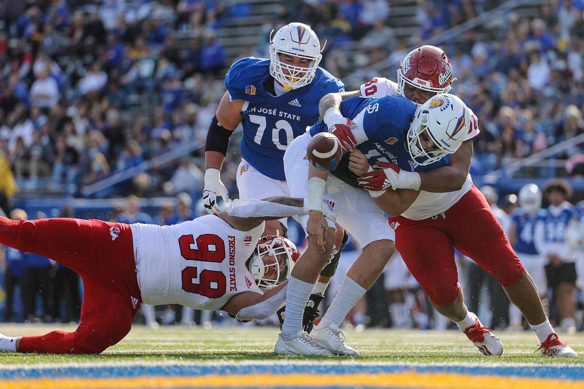 Fresno State defensive end David Perales (99) and defensive tackle Kevin Atkins (90) team up on a sack of San Jose State quarterback Nick Starkel.