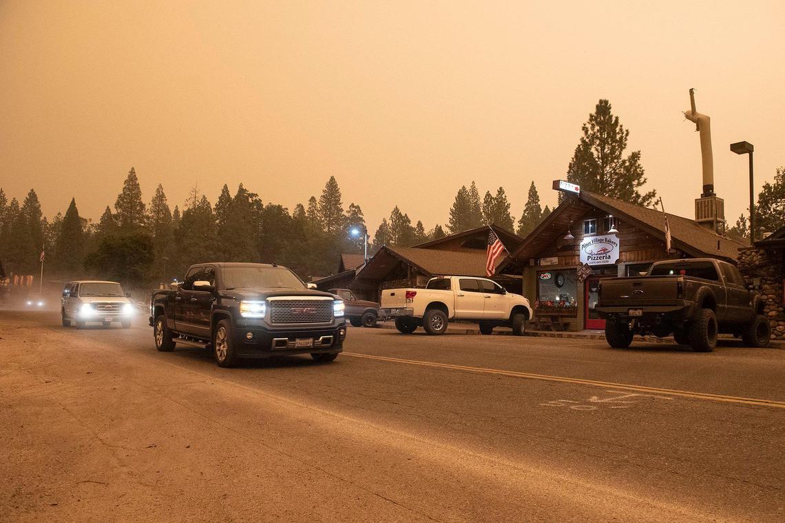 Motorists drive along Road 432 as smoke from the nearby Creek Fire fills the air in Bass Lake, Calif, on Sunday, Sept. 6, 2020.