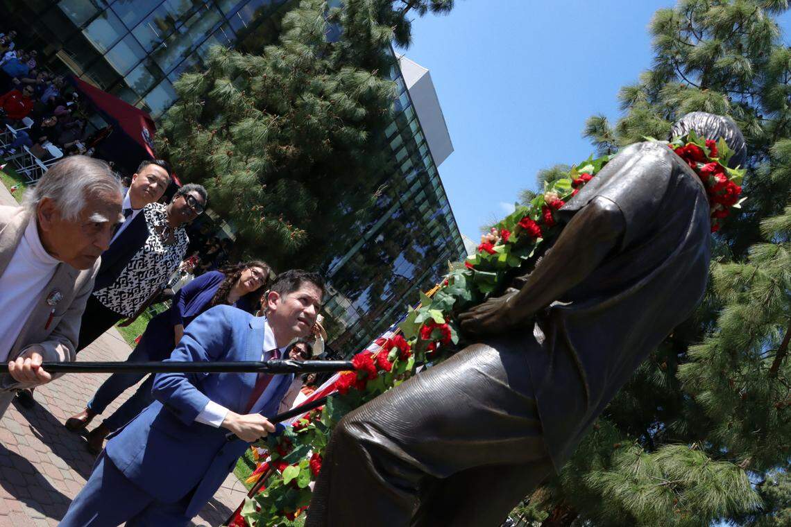 Fresno State President Saúl Jiménez Sandoval and Dr. Sudarshan Kapoor place a garland on the statue of César E. Chávez at the university’s Peace Garden on March 27, 2025.