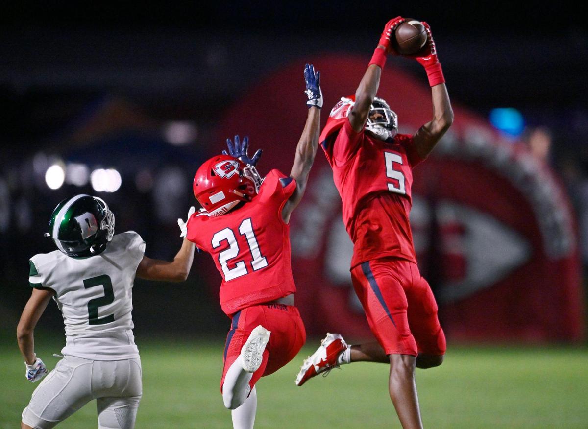 Sanger’s Marquis Cropper, right, intercepts a pass intended for Dinuba’s Dominique Nunez, left, in the first quarter Friday, Aug. 18, 2023 in Sanger.