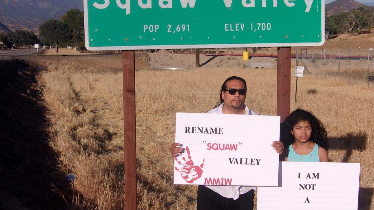 Roman Rain Tree with his 10-year-old daughter, Lola, in front of the town sign for Squaw Valley in Fresno County, California.
