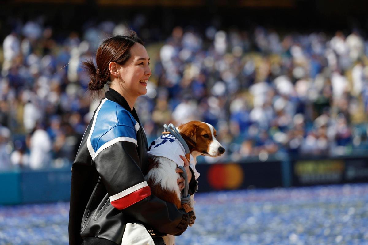 La esposa de Shohei Ohtani, Mamiko Tanaka, lleva a su perro Decoy después de la ceremonia de victoria de la Serie Mundial de Los Angeles Dodgers en el Dodger Stadium este viernes, en Los Ángeles (Estados Unidos).