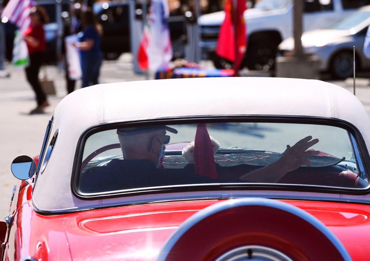 A veteran waves from his Ford Thunderbird as he drives through a ceremony honoring service men and women in observance of National Vietnam War Veterans Day on Monday afternoon, March 29, 2021, at the Fresno Vet Center at Shaw Avenue and Sixth Street.