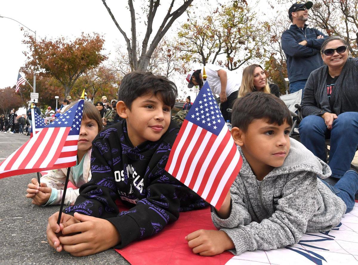 Siblings from left, Trinity Hernandez, 5, Xavier, 10, and Logan, 8 watch the Central Valley Veterans Day Parade, Thursday Nov. 11, 2021.