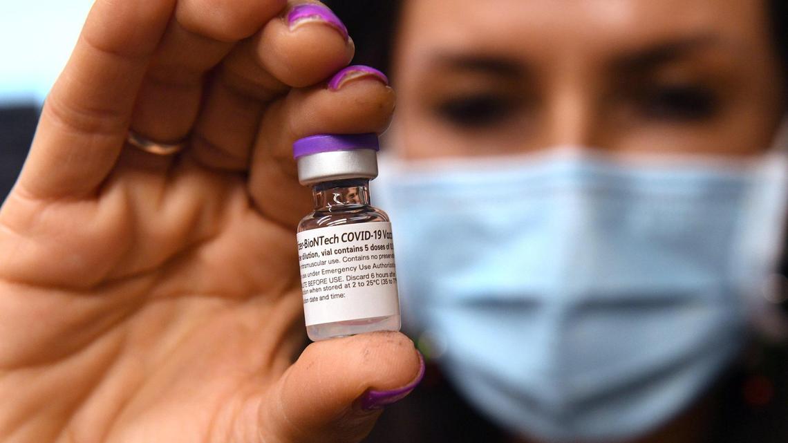 Kaiser Permanente Fresno RN Leticia Ramirez holds a vial of the Pfizer-BioNTech COVID-19 Vaccine, Thursday Dec. 17, 2020. She administered the first of the hospital’s vaccinations to staff, at Fresno, California..