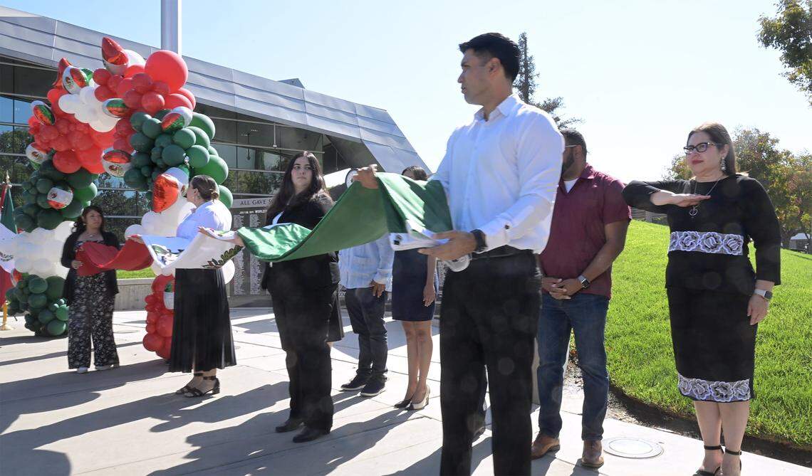 The new Mexican Consul Irma de Los Ángeles Pimentel Portilla, far right, stands as the Mexican flag is raised in front of Fresno City Hall Tuesday, Sept. 16, 2025 in downtown Fresno.