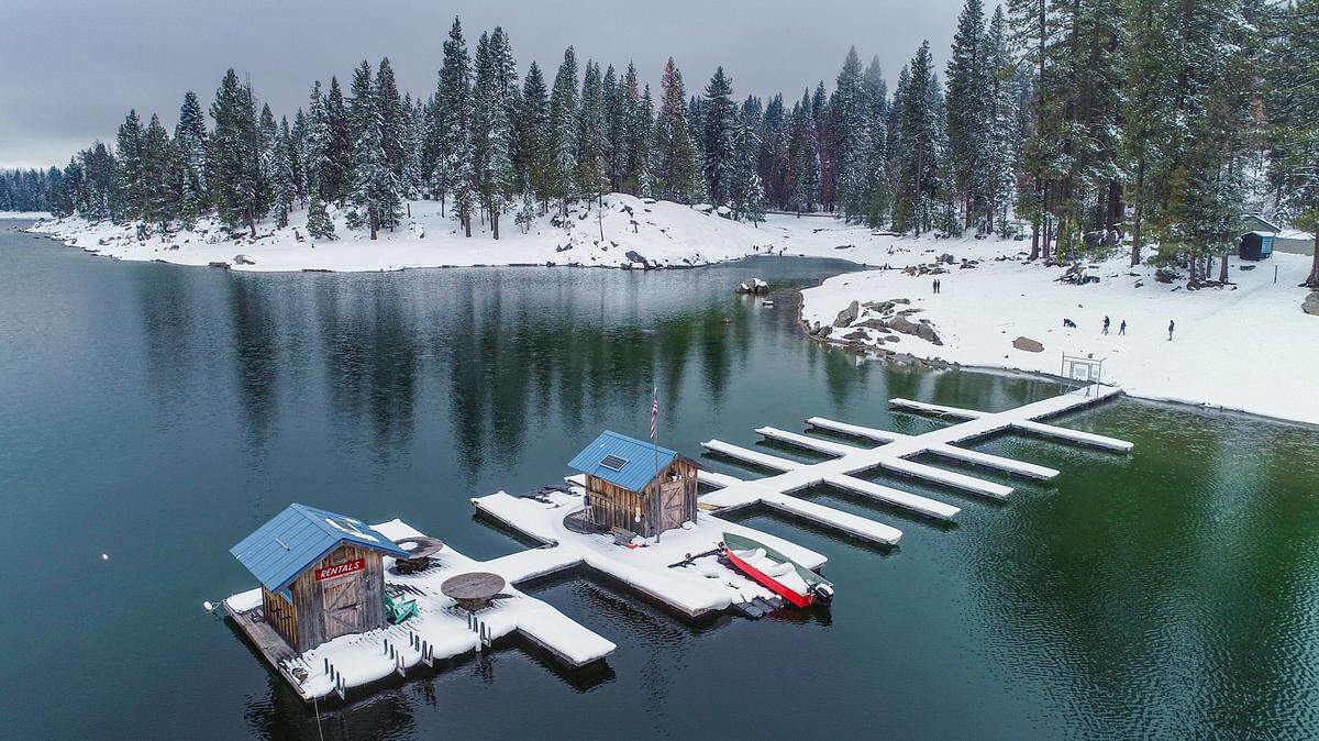 The boat docks at the Shaver Lake marina show a layer of snow along with the trees along the shore as seen in this drone image taken Friday, March 12, 2021 after a storm blew through the area on Wednesday.