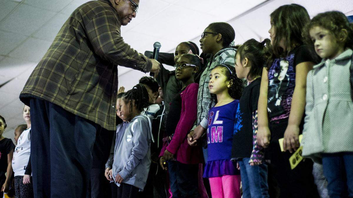 Dr. Napoleon Washington leads the invocation with a group of children during the 20th Annual Martin Luther King Jr. celebration at the Merced County Fairgrounds in Merced, Calif., Monday, Jan. 18, 2016.