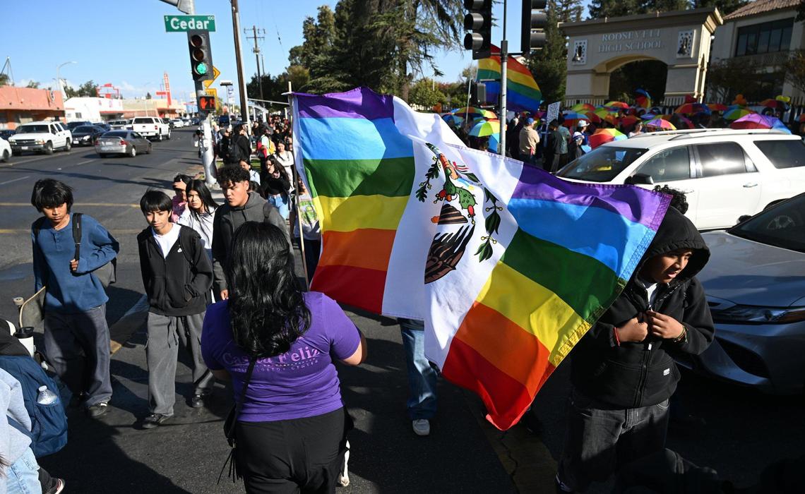 Lady Diana, founder and CEO of Casita Feliz, bottom center, carries a Mexican Pride flag as a coalition of LGBTQ+ organizations and supporters held a counter-protest outside Roosevelt Hgh School featuring rainbow-themed umbrellas as symbolic shields for students against a group from Westboro Baptist Church Monday, Oct. 28, 2024, Fresno.
