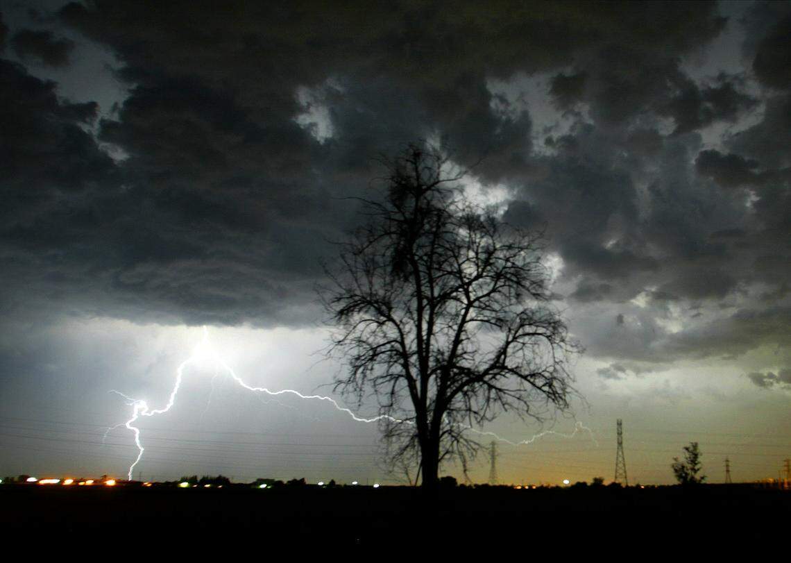 Lightning strikes beyond a tree north of Selma on Sept. 20, 2005.