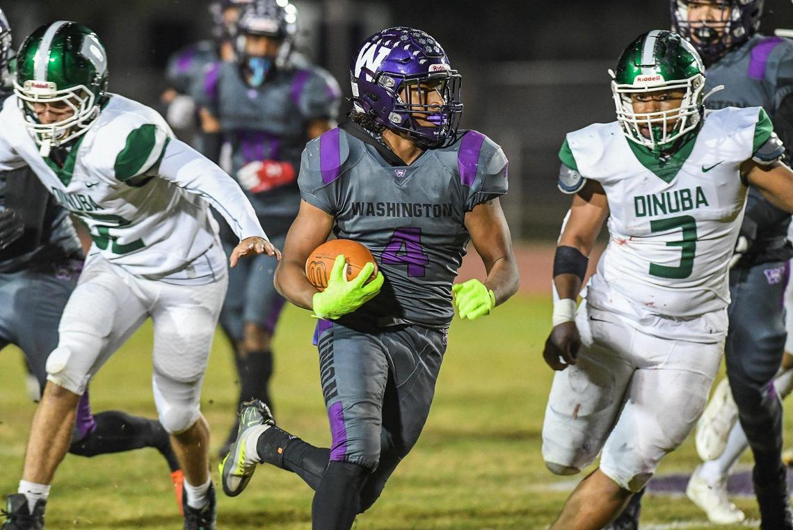 Washington Union’s Joshua Vega, center, finds an opening against the Dinuba defense on a run in their Central Section Division II playoff game at Jesse Ventura Stadium in Easton on Friday, Nov. 4, 2022.