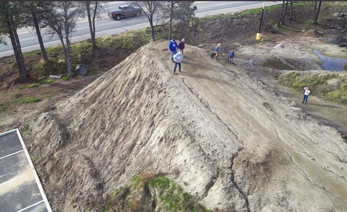 Visitors to the 20-foot high mound of dirt dubbed Mt. Chipotlebegin to descend Friday, Jan. 3, 2025 in Oakhurst. The mound located next to a new Chipotle Mexican Grill may be permanently removed in a few days but until then the community of Oakhurst and others from around the Valley are enjoying the dirt made famous in social media posts.