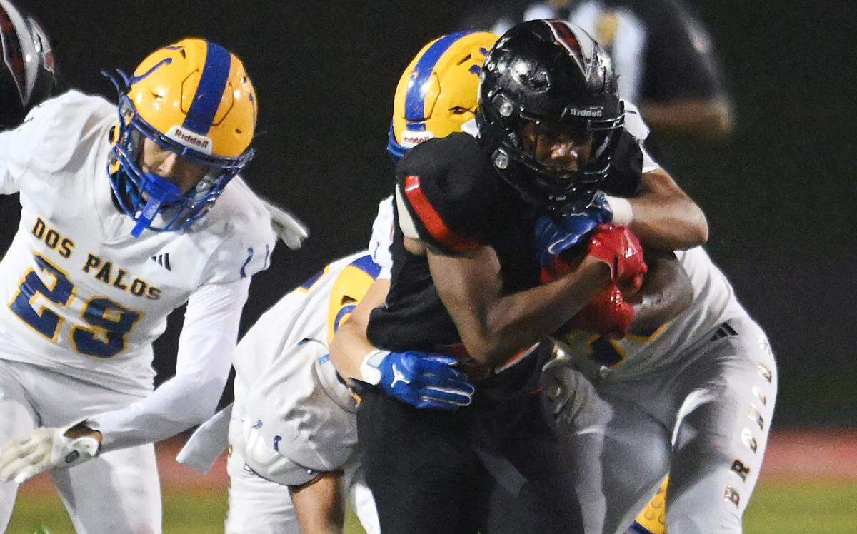 McLane running back Dimareea Banks, center, drives through the Dos Palos defense in the Highlanders' 46-7 routing of the Broncos Friday, Nov. 14, 2025 in Fresno.
