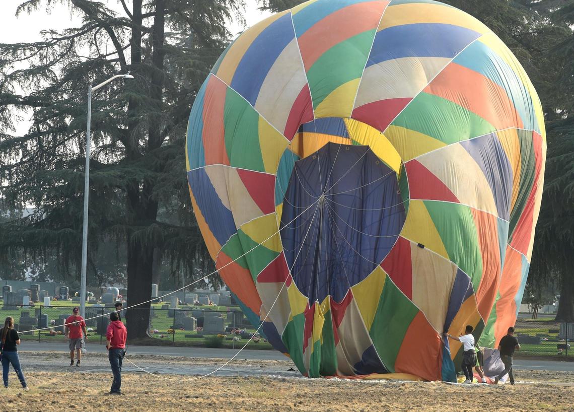 A ground crew stabilizes a balloon across from the Clovis Cemetery as part of the Hot Air Balloon Fun Fly, which kicked off ClovisFest early Saturday, Sept. 25, 2021. ClovisFest features more than 250 craft, commercial and food booths.