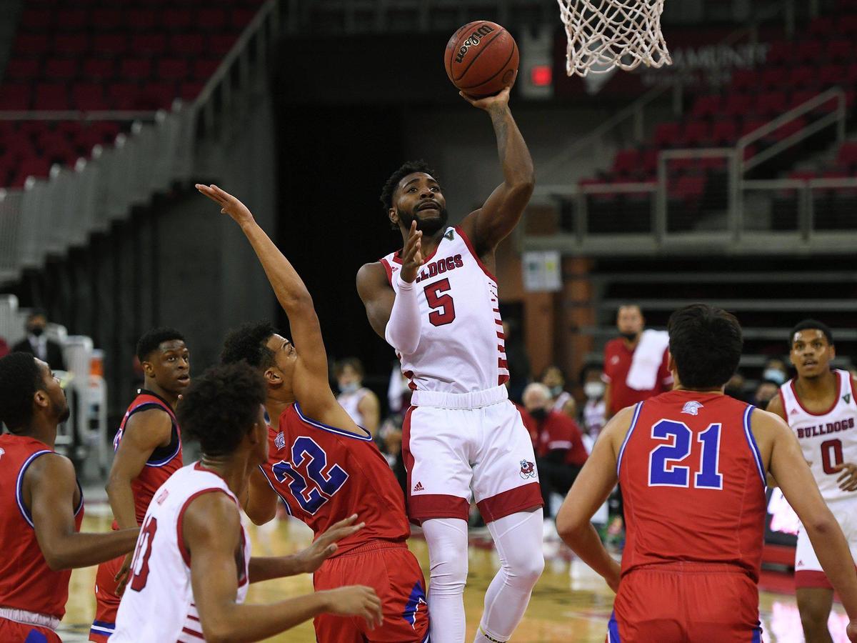 Fresno State guard Jordan Campbell, center, gets a shot up over with William Jessup’s Jaylen Johnson in the Bulldogs’ 87-47 victory Wednesday afternoon, Nov. 25, 2020 in Fresno.