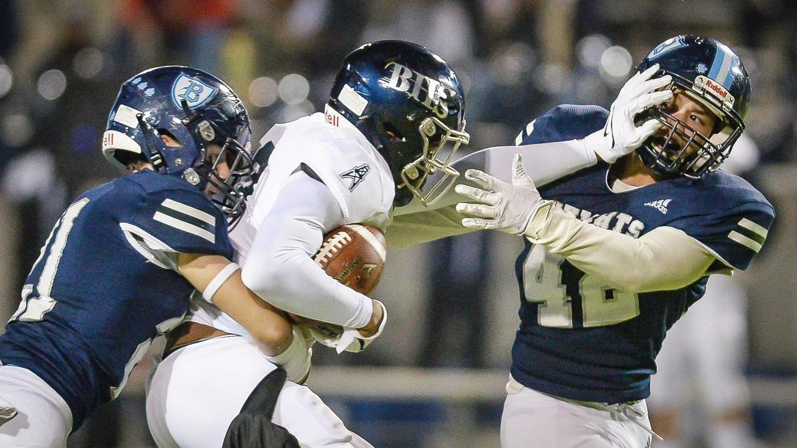 Bullard’s Koda Lamanuzzi, left, and Adan Delgadillo, right, try to put a stop on Bakersfield’s Tybo Rogers during their Central Section Division II football championship game held at McLane Stadium on Friday, Nov. 26, 2021.