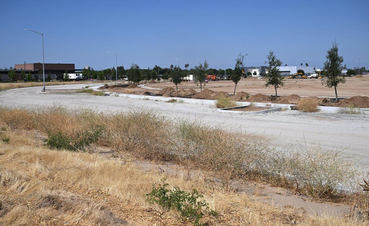 The foundation of a street circling West Creek Village, a 10-acre park under development along South Martin Luther King Jr. Blvd just south of Church Ave. in west Fresno is seen Friday, June 27, 2025. The park is next to the Fresno City College West Fresno Center, left background, and across the street from Gaston Middle School, seen to the right background.