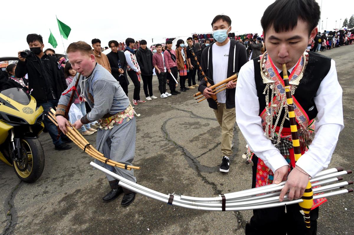 Qeej players perform a traditional song as they march in the opening day parade ushering in the Hmong New Year celebration at the Fresno Fairgrounds, Thursday morning, December 30, 2021.