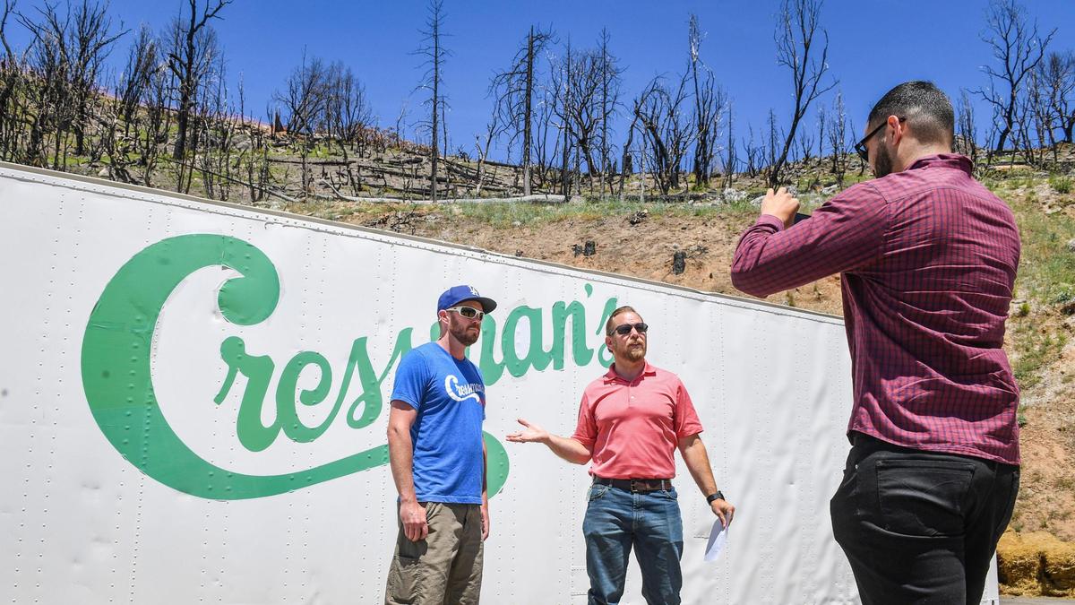 Fresno County Supervisor Nathan Magsig, center, holds a Facebook Live broadcast with Ty Gillett, owner of Cressman’s General Store, at the site of the store which burned down in the Creek Fire last year, on Friday, May 28, 2021. Gillett is hoping to reopen a scaled-down version of the store out of a retrofitted storage container as soon as Memorial Day weekend while he works toward building new structures where the historic store once stood.