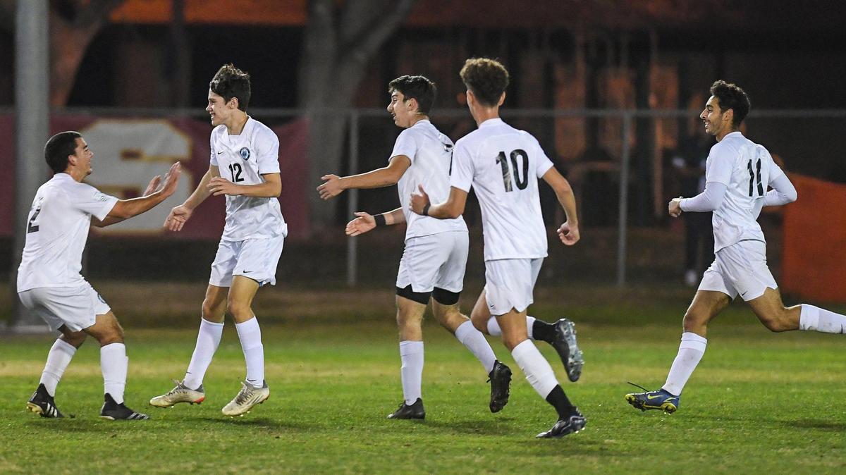 Clovis North players congratulate Matt Swayback, second from left, after scoring the first goal of their game against Clovis West at Tice Park in Fresno on Friday, Jan. 28, 2022.