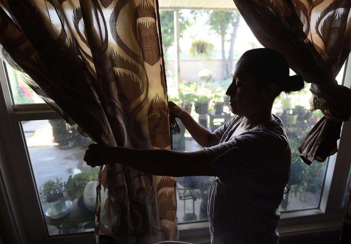 Gina Diaz-Nino, drawing curtains at her grandmother’s house, said that she feels isolated because of her teeth- ravaged by years of drug abuse and injury- which she says now harms her ability to get a job, interact with people and gives her low self-esteem.