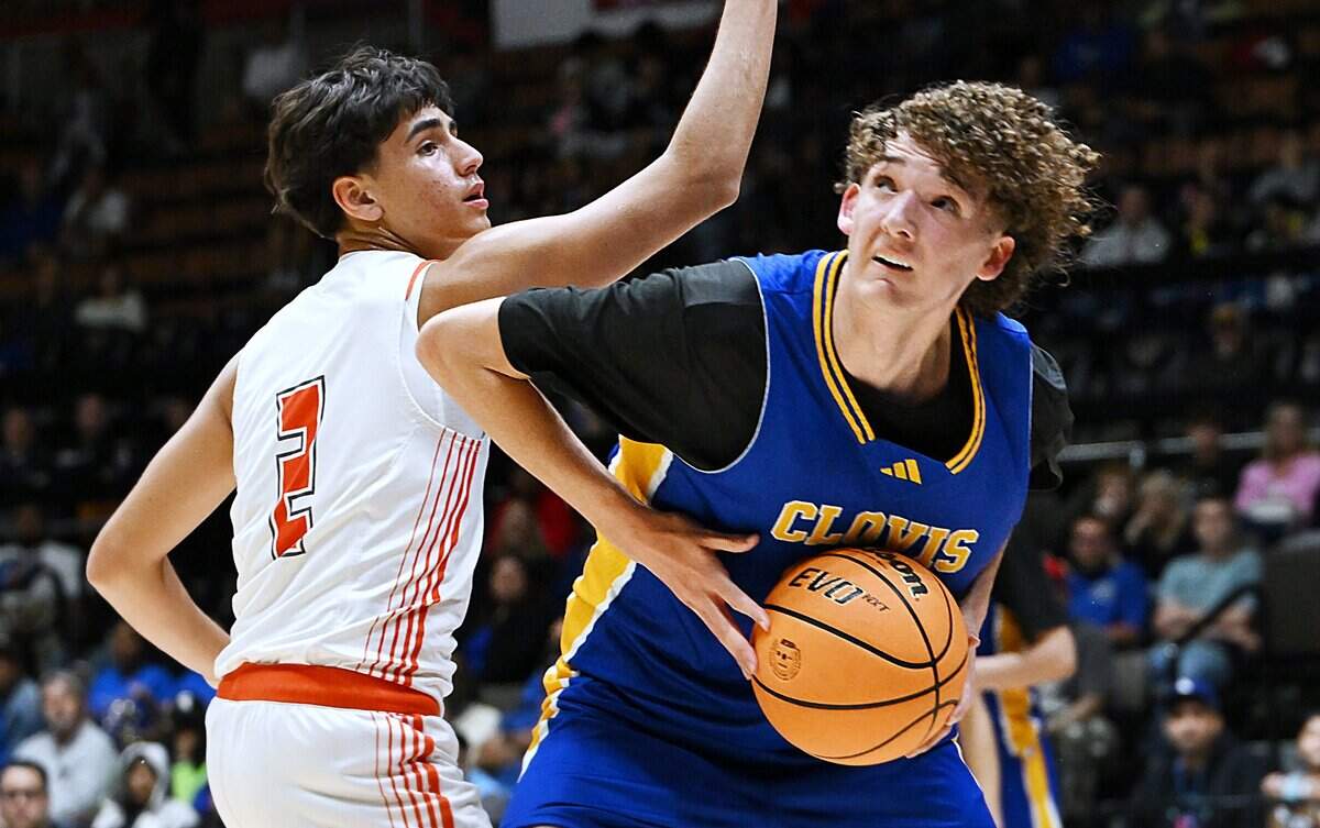 Clovis High's Jackson Scarborough, right, drives past Atascadero's Isaiah Rodriguez, left, in the CIF Central Section 2025-2026 DII Boys Basketball Championship held Friday, Feb. 27, 2026 at Selland Arena in Fresno.